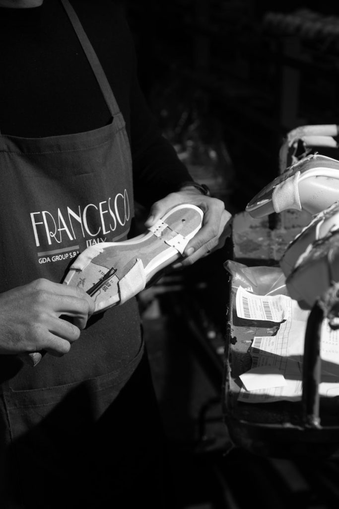 In questa foto in bianco e nero un artigiano durante la lavorazione di un paio di scarpe Francesco Italy 