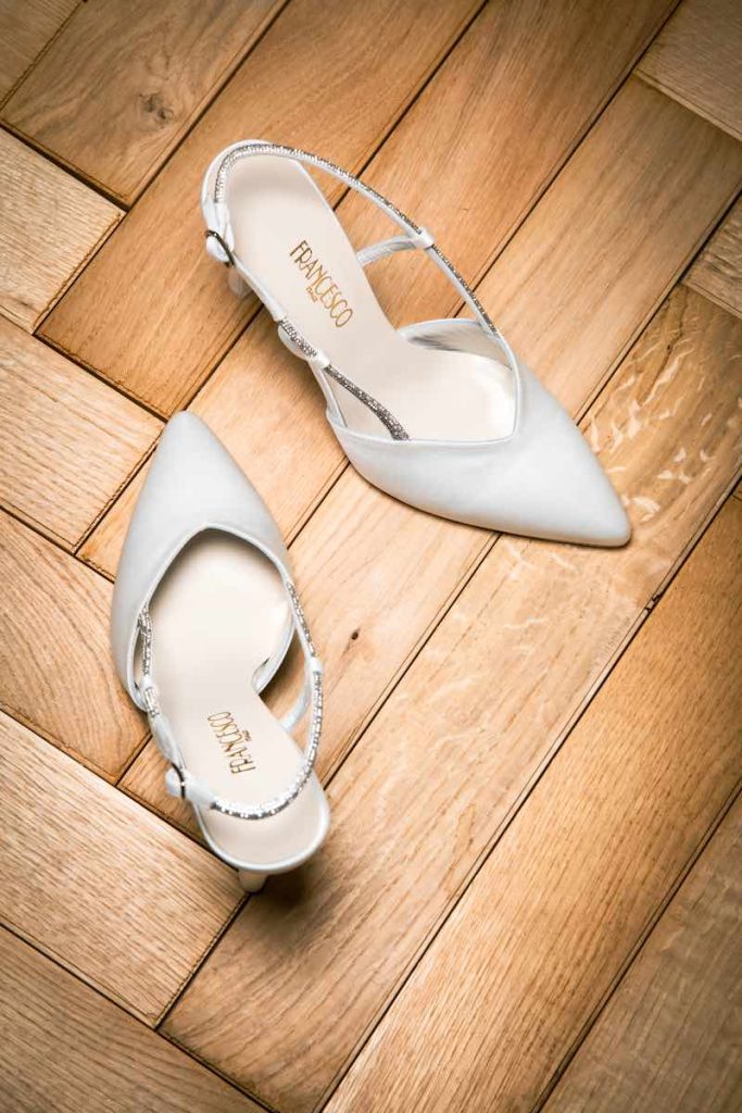 In questa foto inquadrata dall'alto un paio di scarpe da sposa slingback Francesco Italy 2024 con applicazioni di cristalli sul cinturino