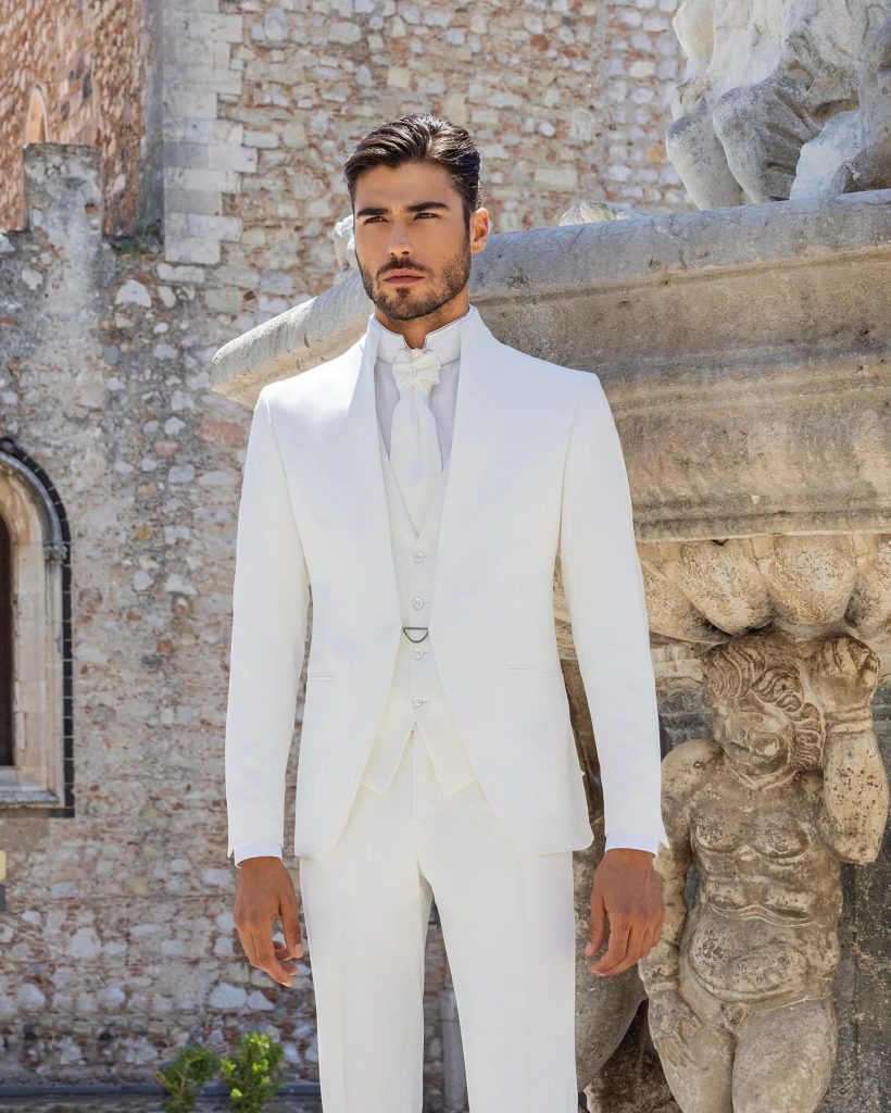 In questa immagine il modello indossa un abito da sposo colorato bianco Scribano