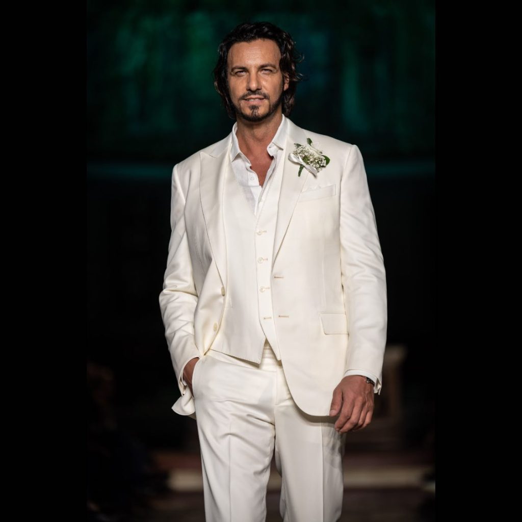 In questa immagine il modello indossa un abito da sposo colorato bianco Sergio Nesci