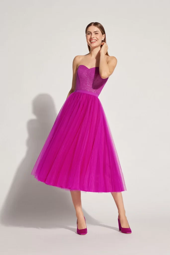 In questa foto una modella indossa un abito da cerimonia 2024 con top a cuore e gonna a ruota in tulle di Atelier Emé