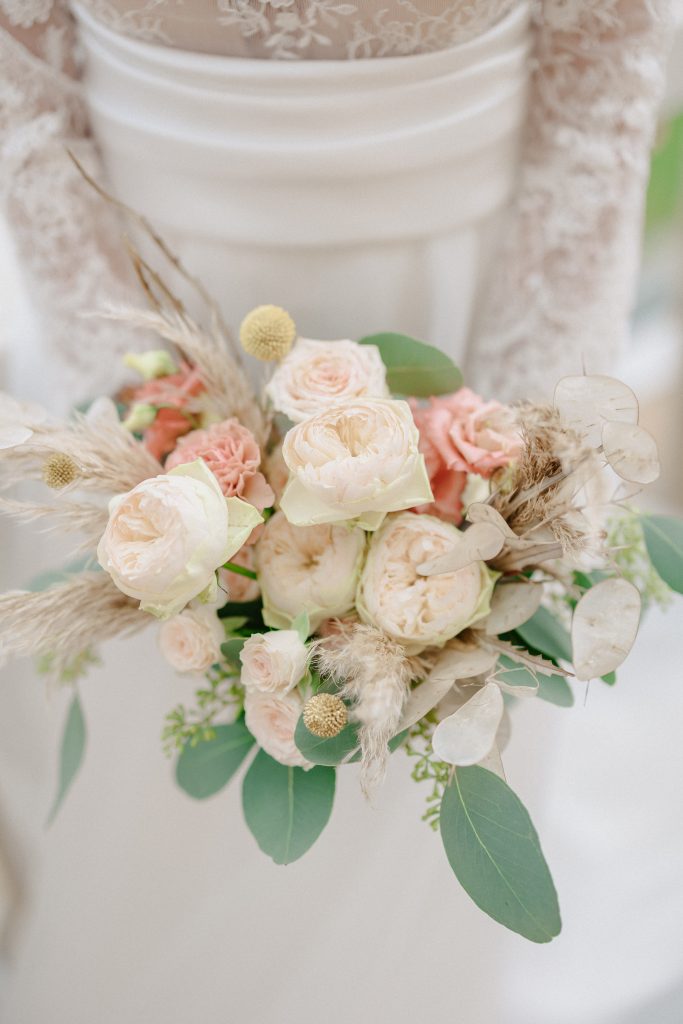 In questa immagine un bouquet sposa 2024 con peonie bianche e fiori nelle tonalità chiare. 