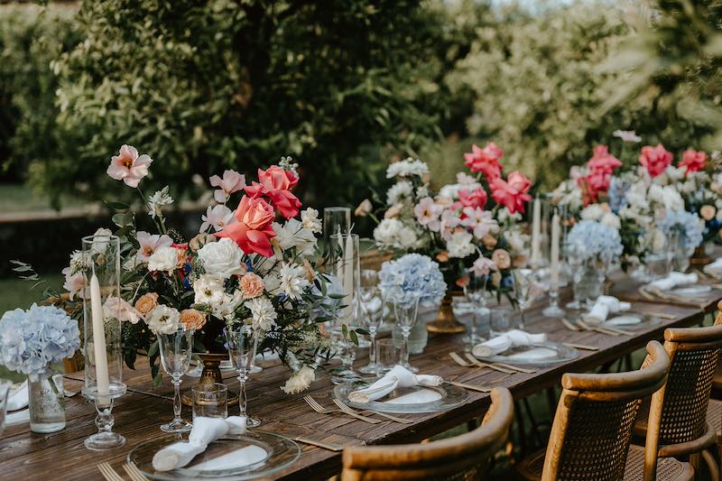 In questa foto la mise en place di un Elopement Wedding in Sicilia progettato da Tania Costantino con fiori di colore rosso, celeste e bianchi 