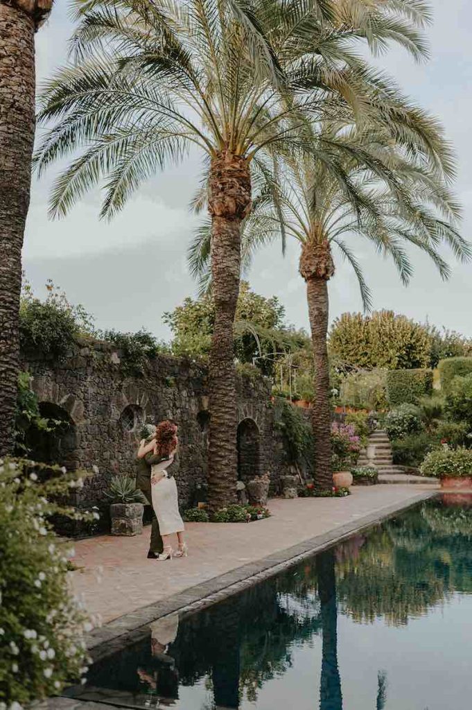 In questa foto due sposi si abbracciano a bordo di una piscina in una villa privata di Catania