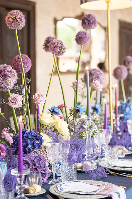 In questa foto una mise en place con fiori viola e blu