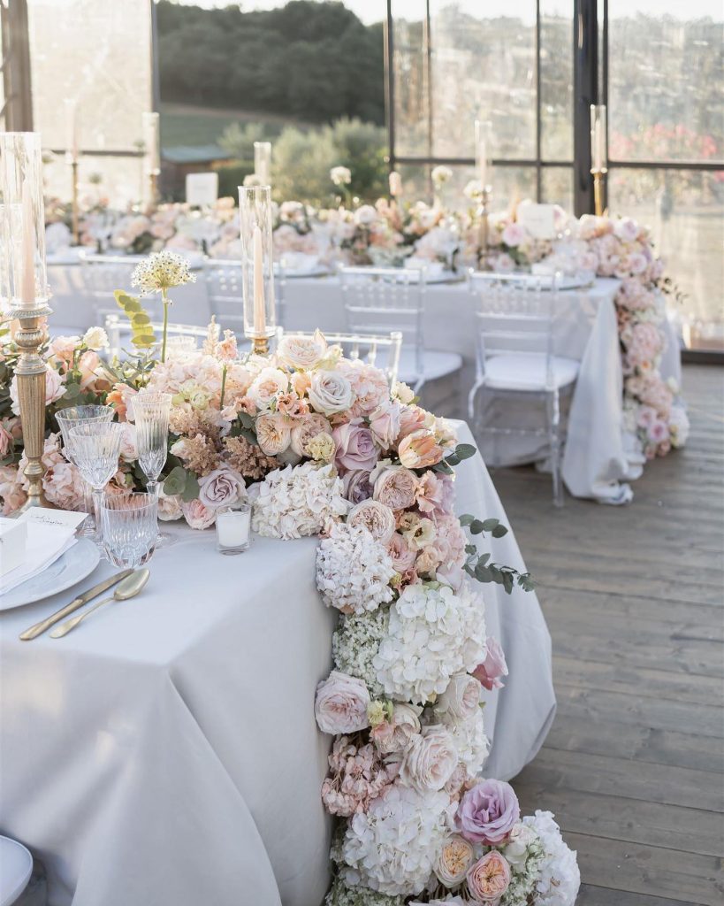 In questa foto un tavolo con fiori di matrimonio con colori pastello