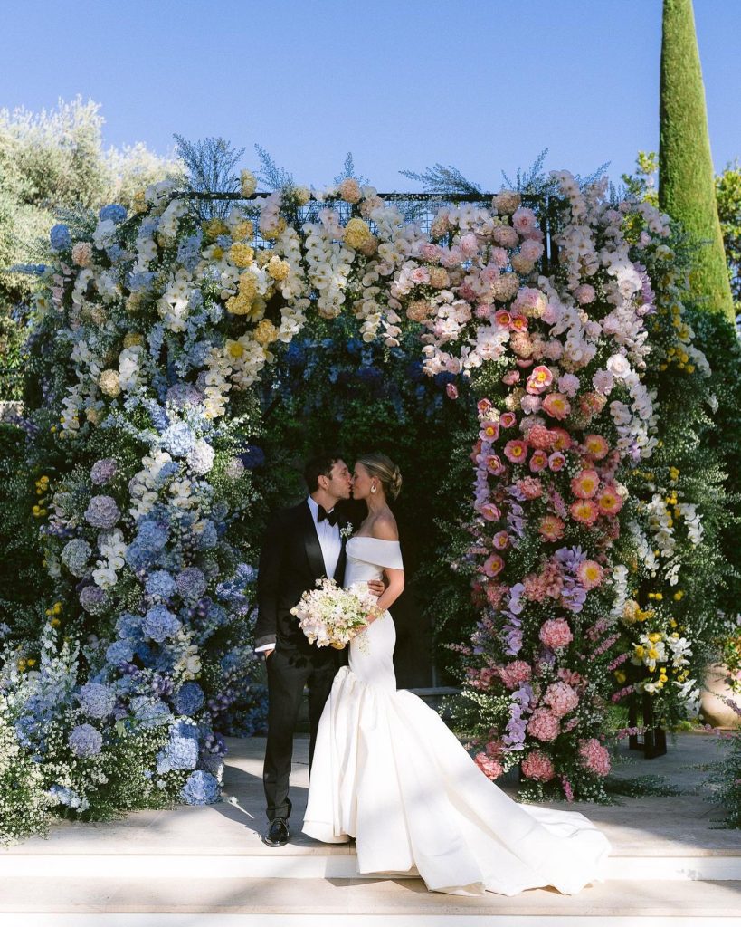 In questa foto un allestimento floreale di matrimonio 2024 con arco con fiori multicolor
