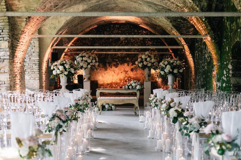 In questa foto la sala di un matrimonio allestita con candele, portacandele in vetro e fiori di colore bianco e rosa