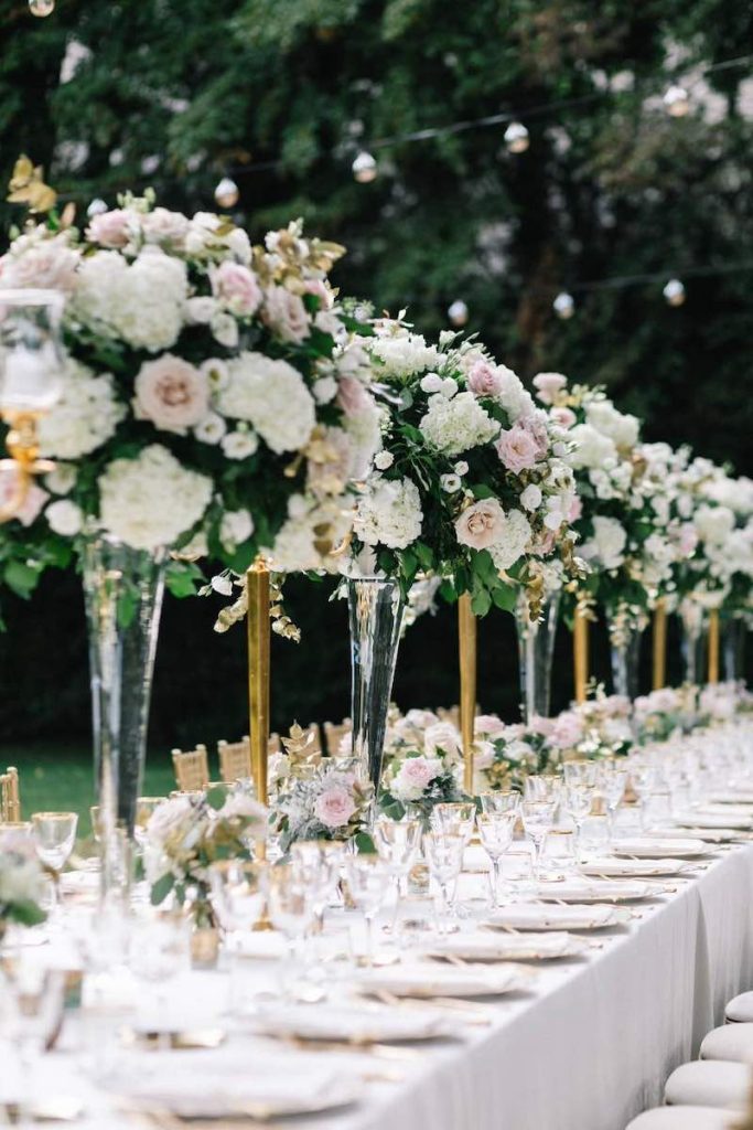 In questa foto un lungo tavolo imperiale allestito da Nives Malvestiti con grandi composizioni di fiori e dettagli di colore ore