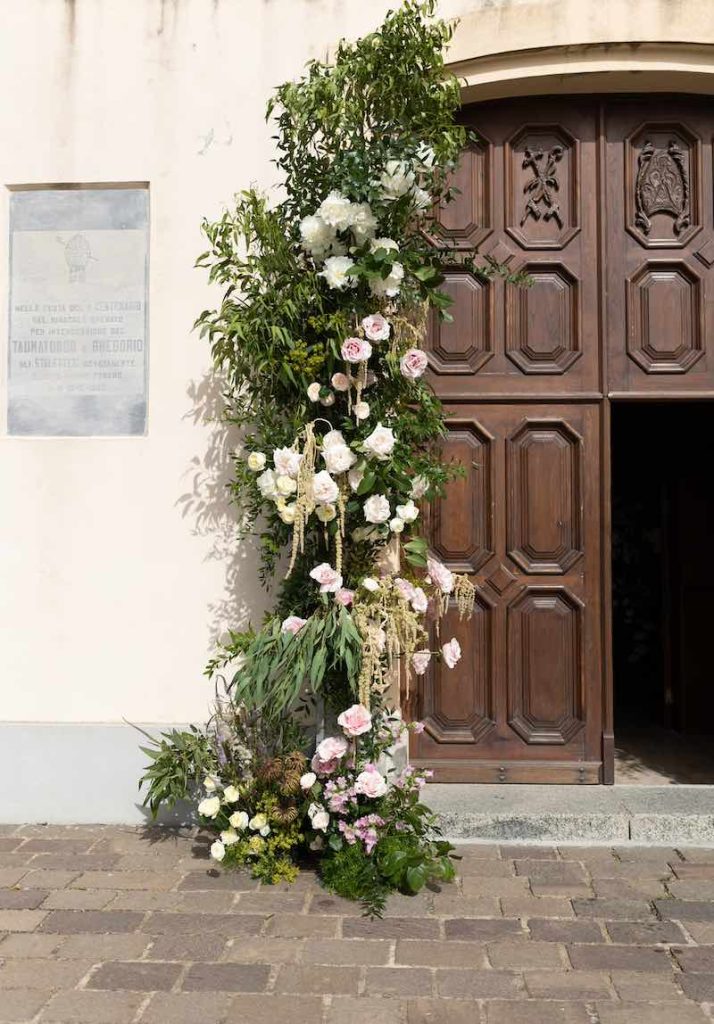 In questa foto l'allestimento floreale dell'ingresso della chiesa per le nozze di Roberta e Domenico firmate dalla Wedding Planner Benedetta Carpanzano, realizzato con rose di colore rosa e giallo