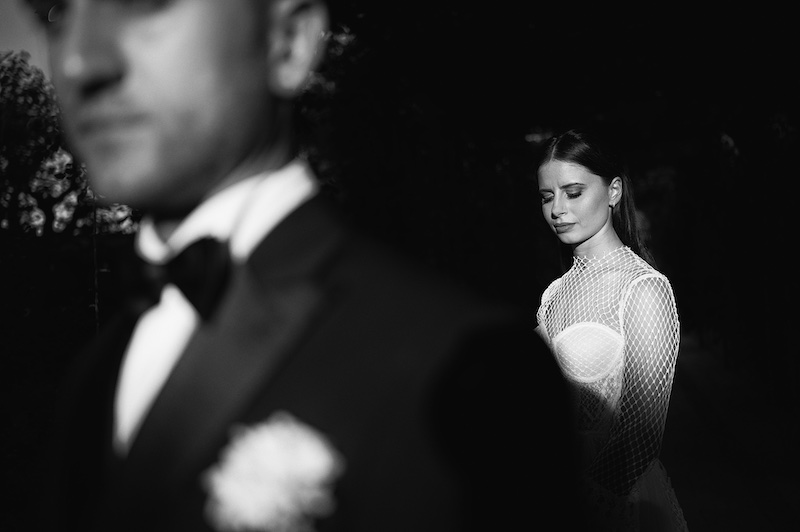 In questa in bianco e nero una sposa dietro ad uno sposo