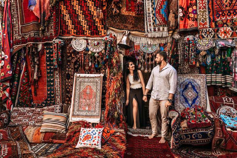 In questa foto una coppia tra i tappeti in vendita in un suq turco