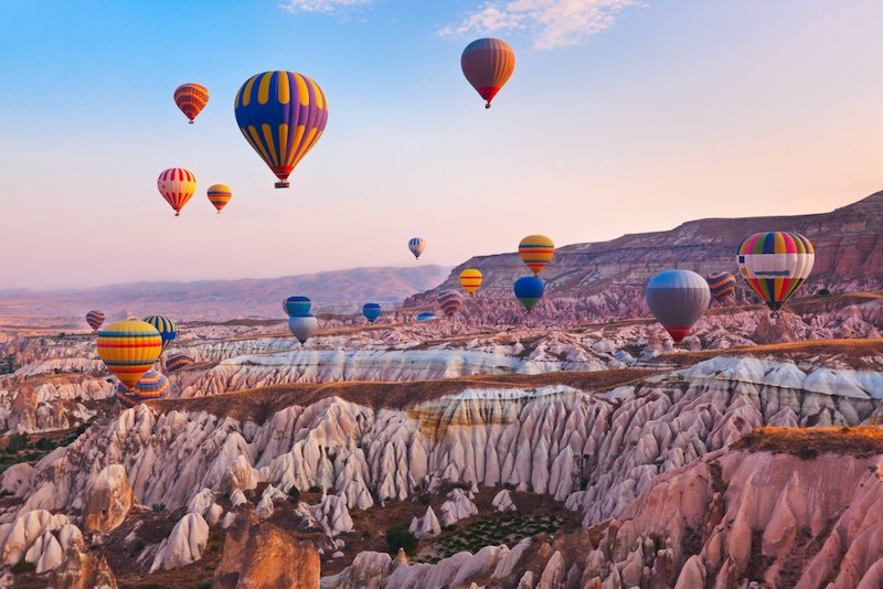 In questa foto una veduta delle tipiche mongolfiere che all'alba sorvolano i cieli della Cappadocia, in Turchia