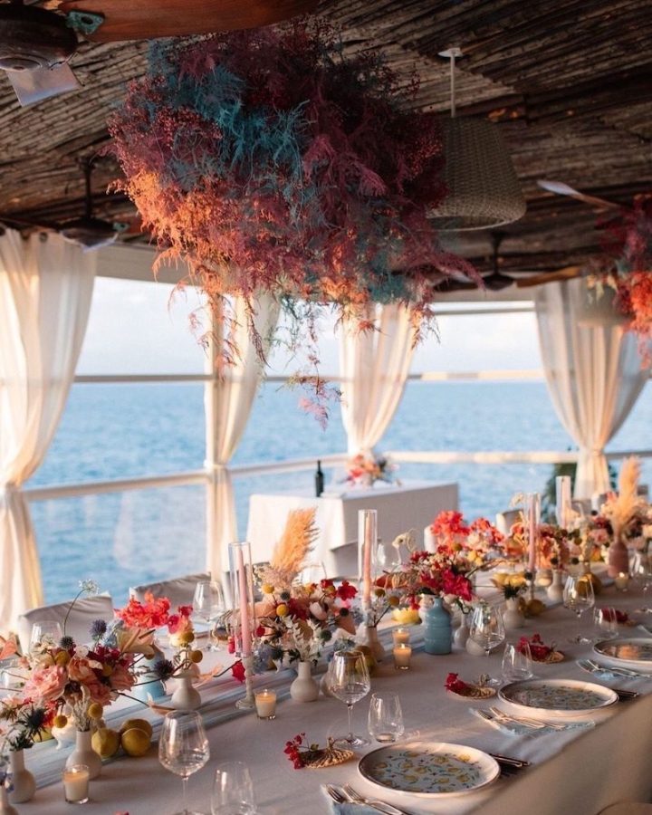 In questa foto un tavolo imperiale addobbato con allestimenti dai colori pop sulla terrazza del ristorante il Riccio di Anacapri