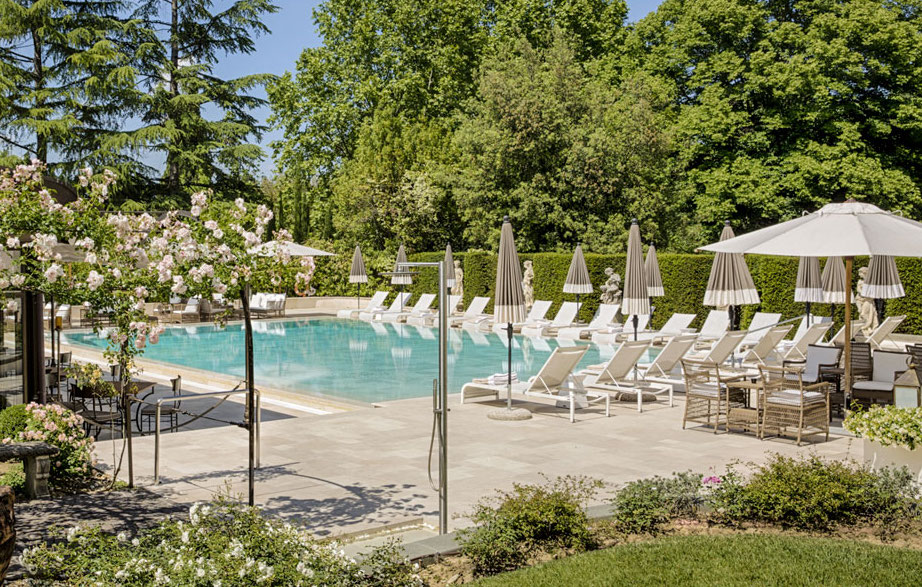 In questa foto l'area della piscina esterna, immersa in un giardino rigoglioso, di Villa Cora a Firenze