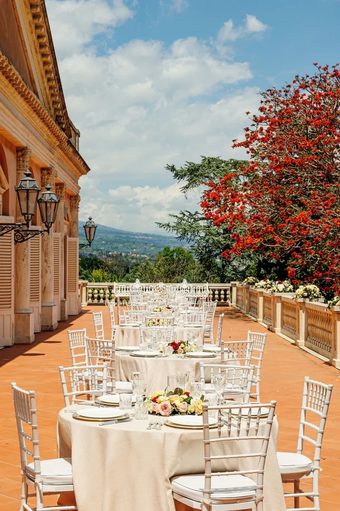 In questa foto la terrazza di Villa La Limonaia addobbata con una serie di tavoli tondi pronti ad ospitare un ricevimento di nozze
