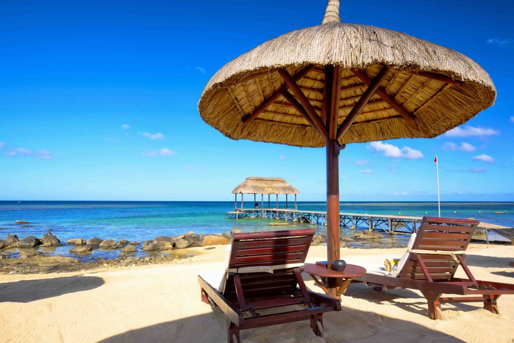 In questa immagine due sdraio e un ombrellone alle Mauritius, una delle mete più amate per la luna di miele.