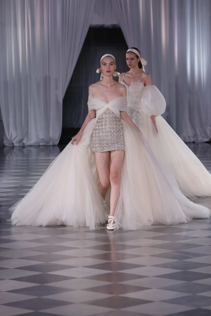 In questa immagine un abito da sposa Giambattista Valli 2025 con gonna corta arricchita da pietre preziose. 