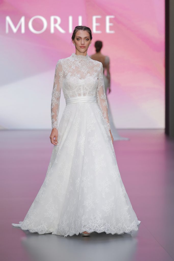 In questa immagine un abito da sposa Morilee 2025 in pizzo. 