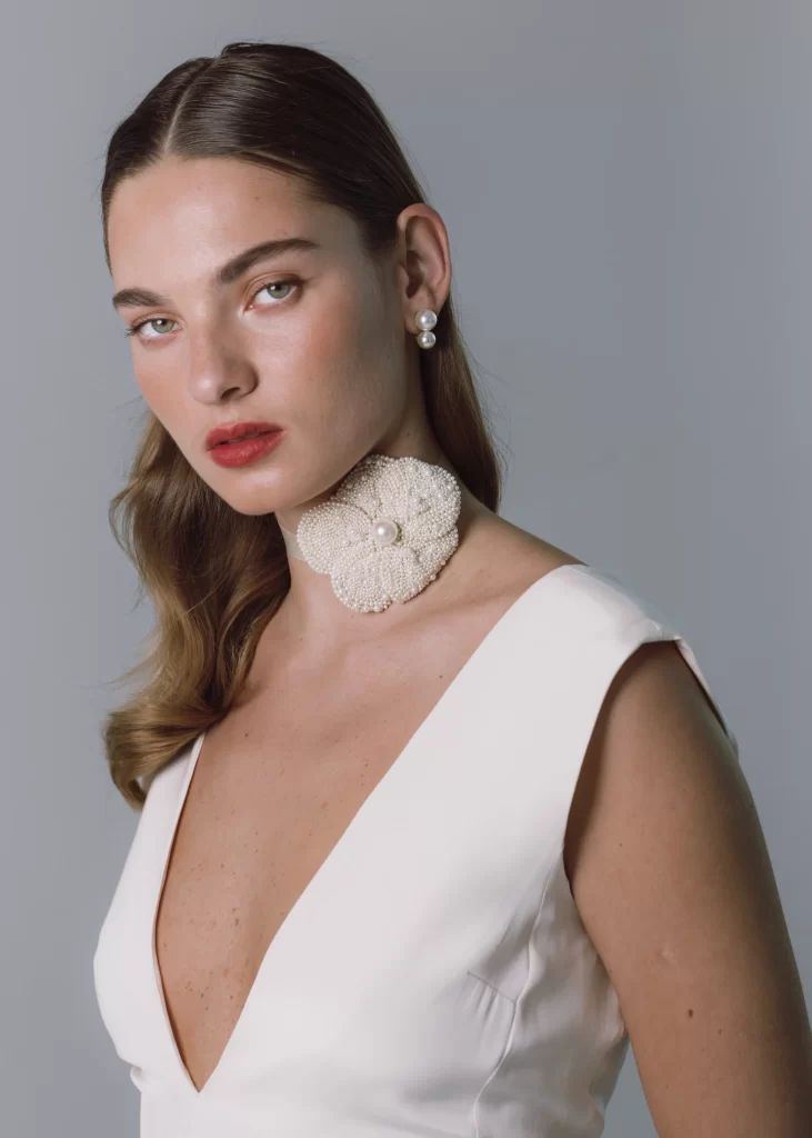 In questa foto la modella indossa una collana di perle con fiore