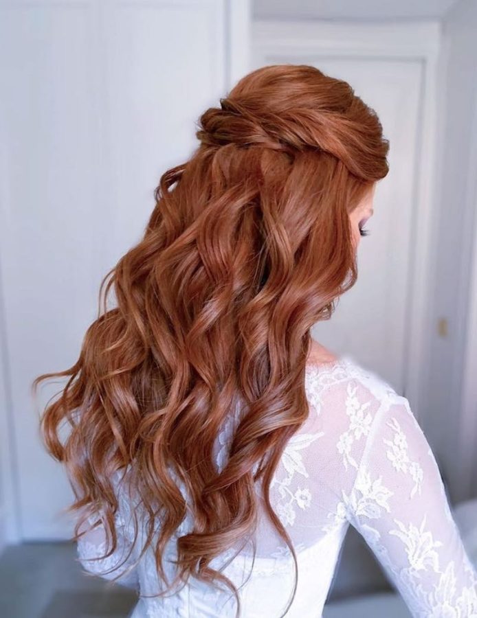 In questa foto un'acconciatura da sposa 2024 per capelli mossi con semi-raccolto 