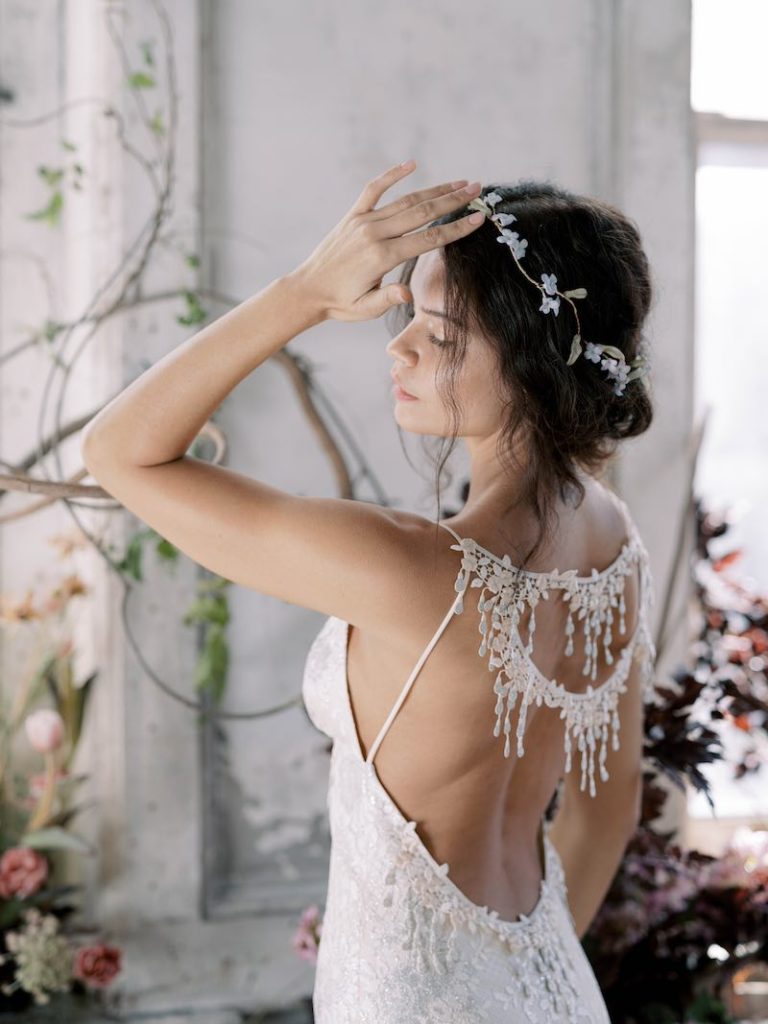In questa foto un'acconciatura da sposa 2024 con un tralcio di foglie e fiori