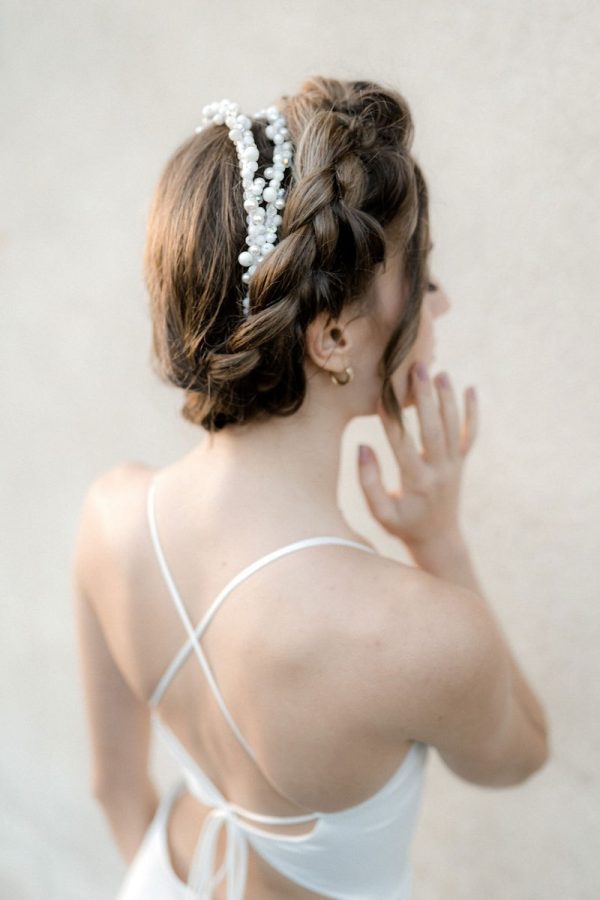 In questa foto un'acconciatura da sposa 2024 con treccia e cherchietto di perline di colore bianco e argento