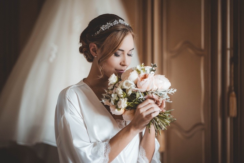 In questa foto di Emiliano Allegrezza una sposa ad occhi chiusi annusa il suo bouquet di rose inglesi e peonie
