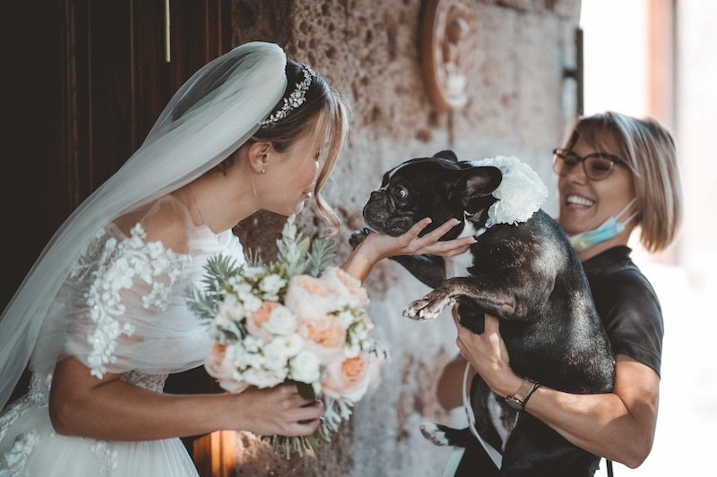 In questa foto di Emiliano Allegrezza una sposa accarezza il suo cagnolino, un Bulldog francese, all'uscita da casa
