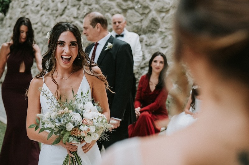 In questa foto di Emiliano Allegrezza una sposa sorride gioiosa all'arrivo della sua sposa all'altare 