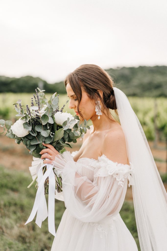 In questa foto la modella indossa un velo bianco e bouquet