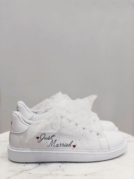 In questa foto scarpe bianche sposa a sneakers