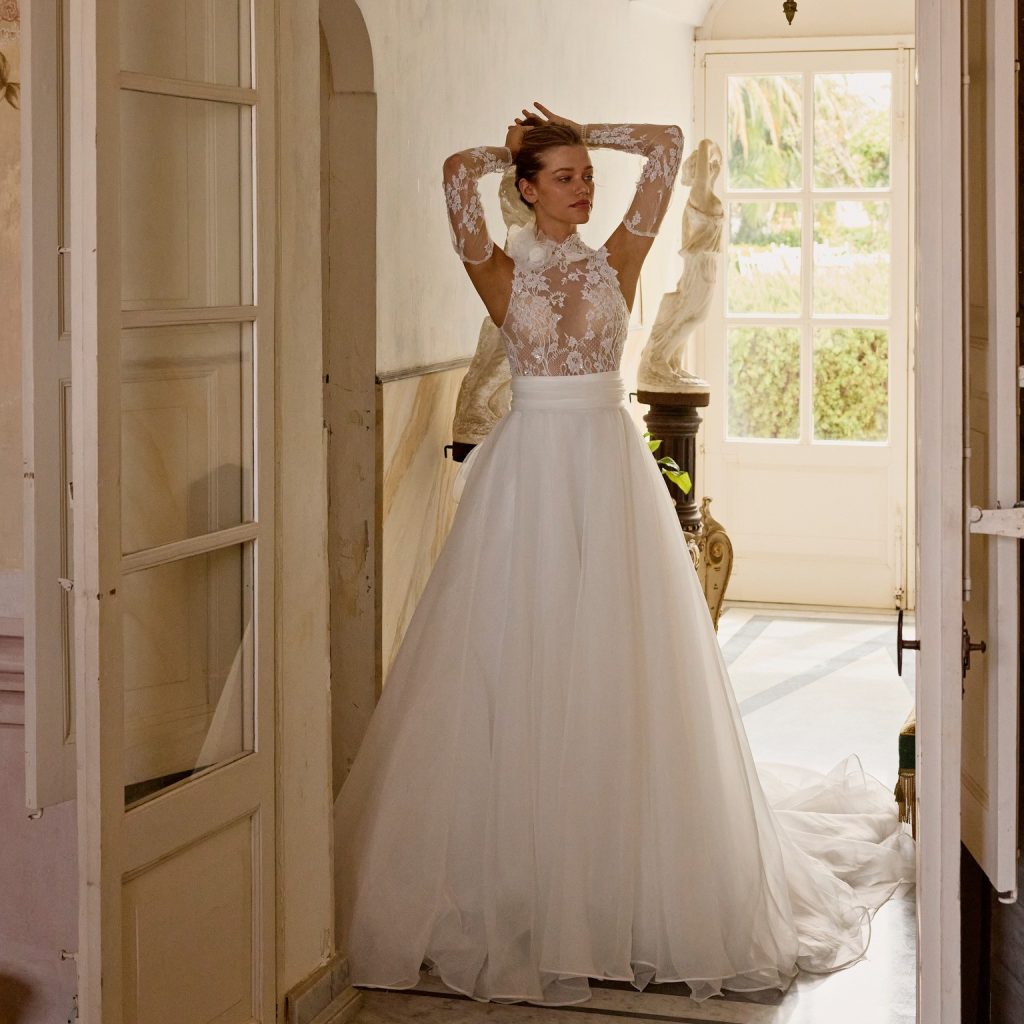 In questa foto la modella indossa un abito da sposa di pizzo 2025 felicia