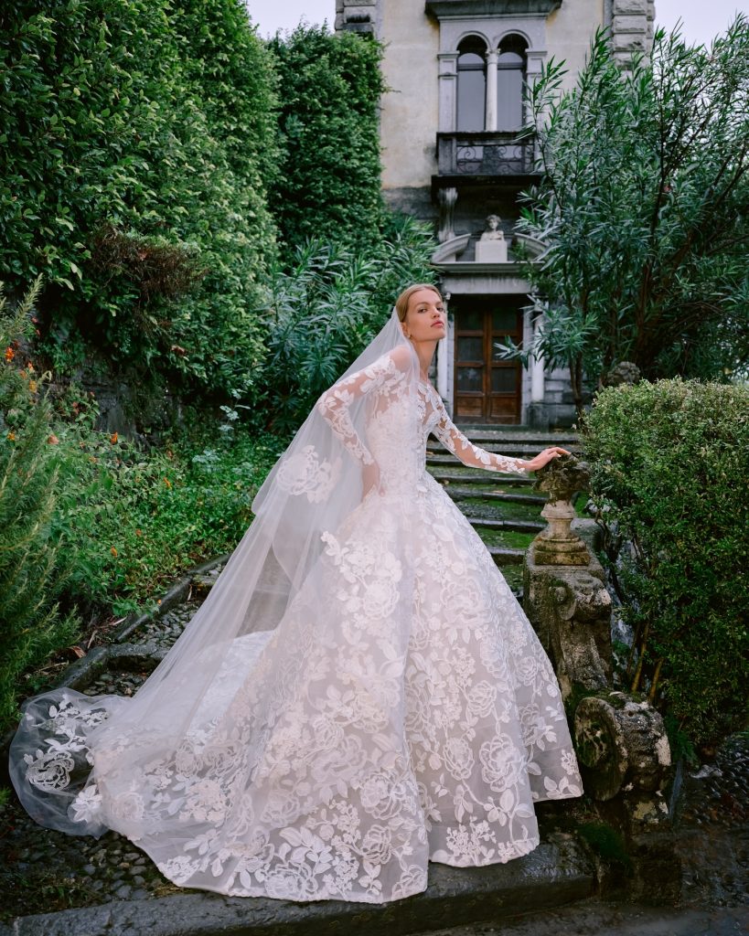 In questa foto la modella indossa un abito da sposa di pizzo 2025