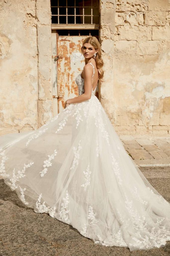 In questa foto una modella indossa un abito principesco con gonna in tulle e ricami floreali 3D della collezione Sincerity Bridal Primavera Estate 2025