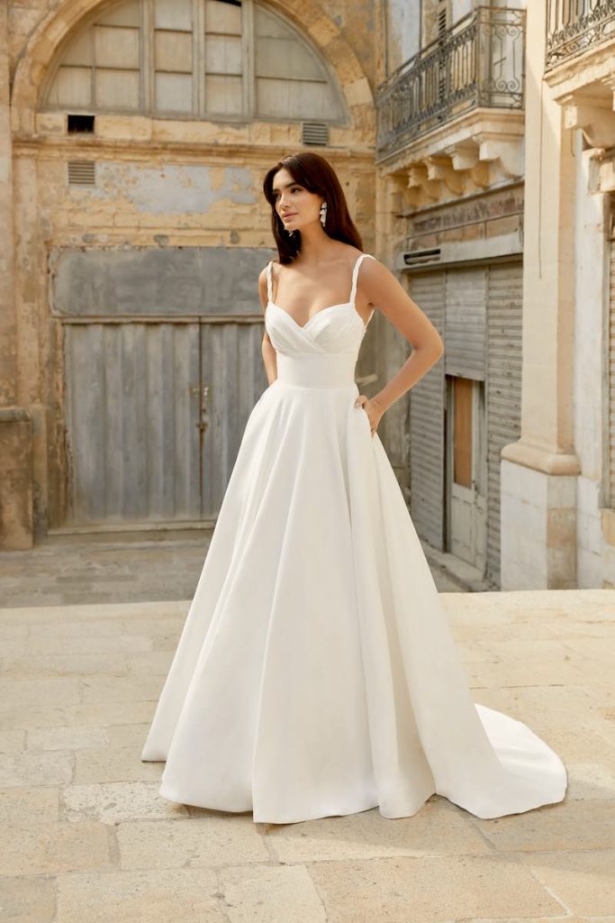 In questa foto una modella indossa un abito da sposa ad A in mikado