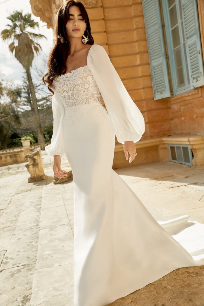 In questa foto una modella indossa un abito da sposa a sirena con maniche ballon in organza