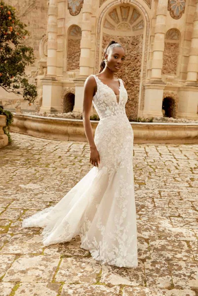 In questa foto una modella indossa un abito da sposa semi sirena in pizzo floreale della collezione Sincerity Bridal Primavera Estate 2025