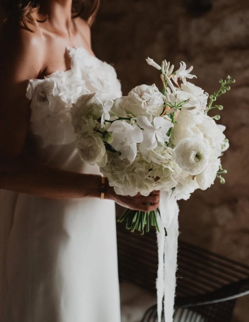 In questa foto, un bouquet da sposa 2025 con fiori bianchi