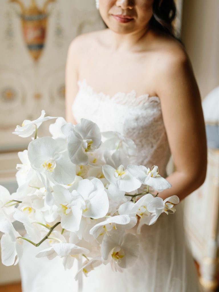 In questa foto, un bouquet da sposa 2025 con orchidee di colore bianco