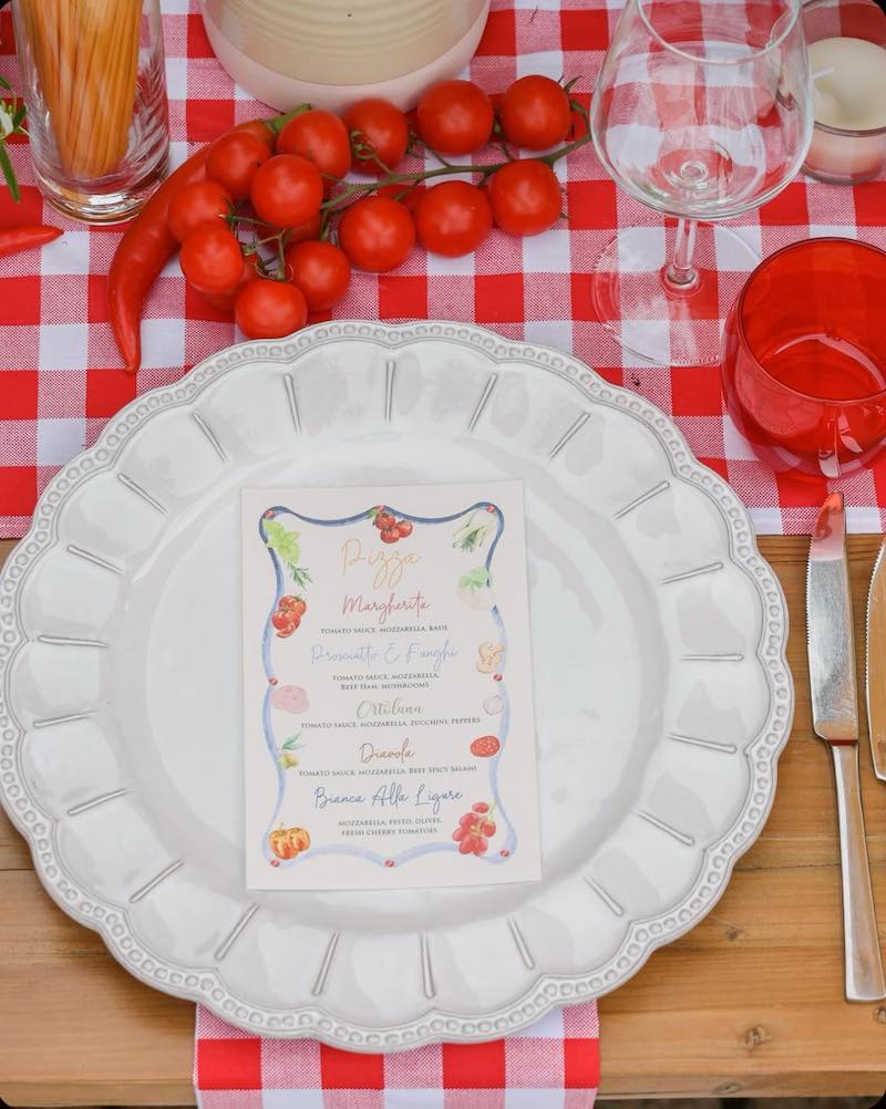 In questa foto, una mise en place per matrimonio nei toni del rosso con pomodori