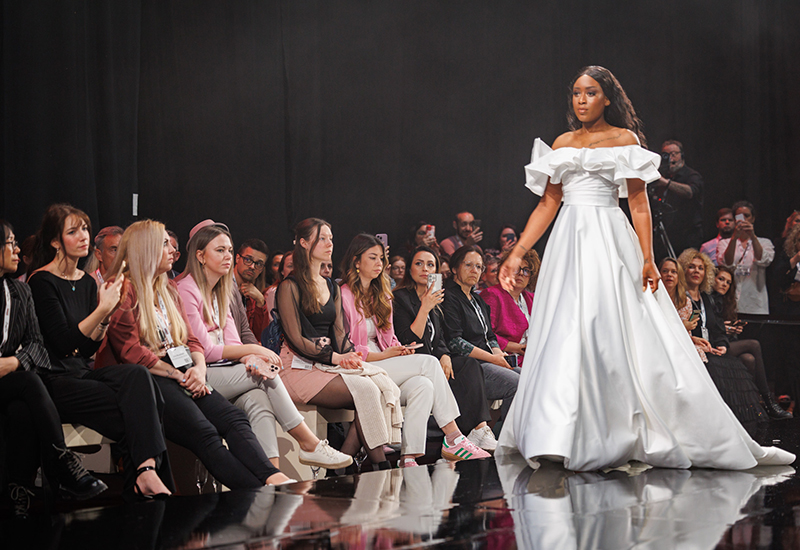 In questa foto una modella con un abito da sposa sfila alal european bridal week 2025