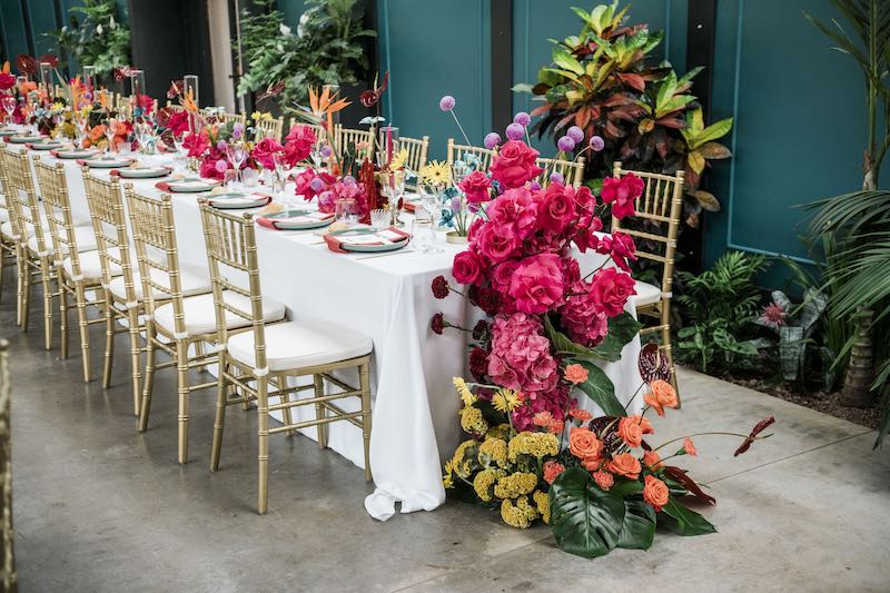 In questa foto, l'allestimento di un tavolo imperiale con fiori multicolor con cascata floreale frontale