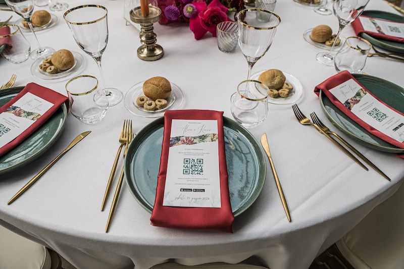 In questa foto, un dettaglio di mise en place con piatti color ottanio e tovaglioli color corallo per il matrimonio multicolor firmato da Clementina Muscolo
