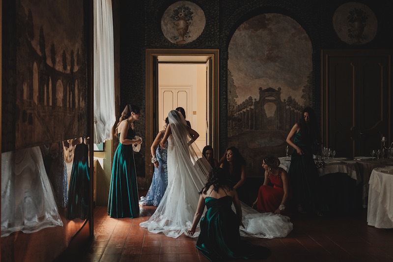 In questa foto di Salvatore Cimino, una sposa si prepara nella sala di un antico palazzo circondata da amiche e damigelle