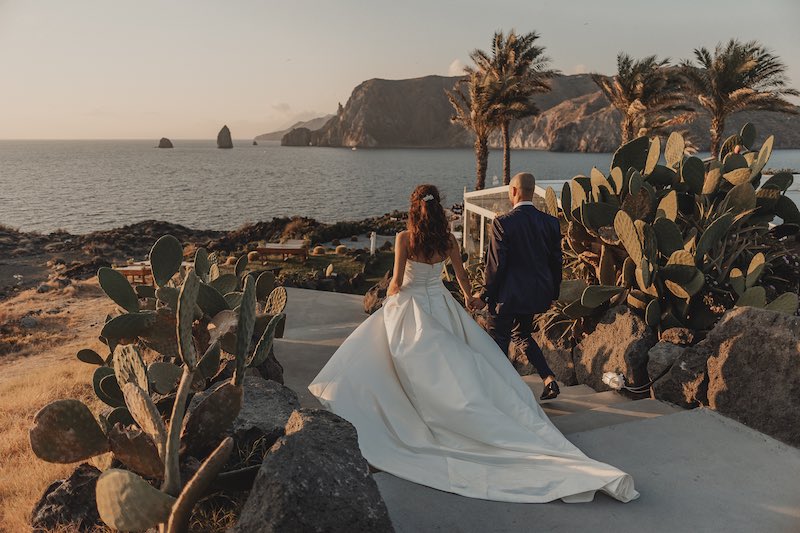 In questa foto di Salvatore Cimino, due sposi camminano di spalle verso il mare 