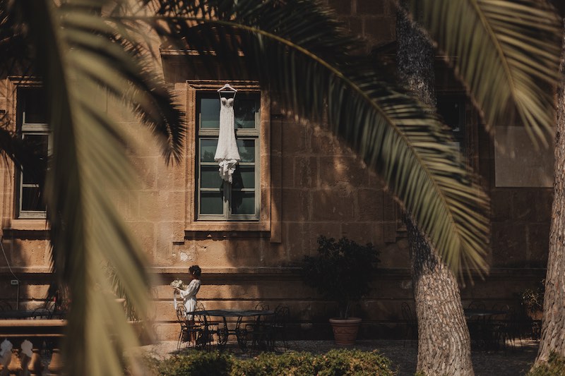 In questa foto di Salvatore Cimino, una sposa guarda il bouquet nel giardino di un antico palazzo
