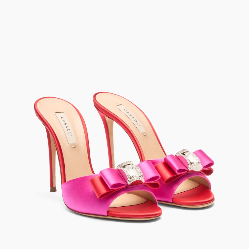 In questa foto, scarpe da cerimonia donna 2025 Casadei modello sandalo mules, colore fucsia e rosso con fiocco gioiello frontale