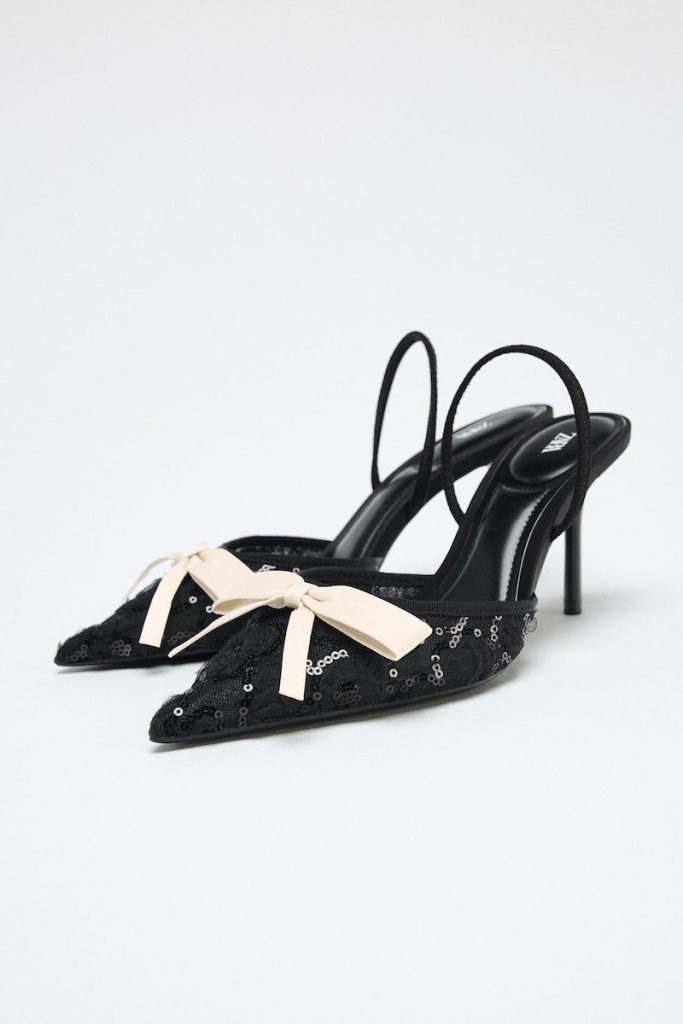 In questa foto, scarpe Zara modello slingback, colore nero con applicazione di paillettes e un fiocco di colore rosa