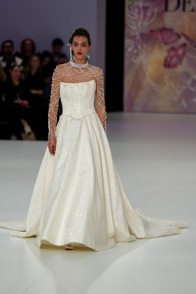 In questa foto la modella indossa un abito da sposa Demetrios 2026